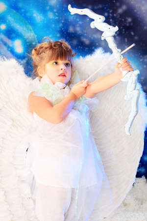 Beautiful little angel at a snowy background.の写真素材