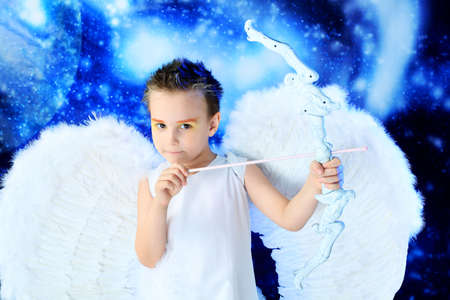 Beautiful little angel at a snowy background.の写真素材