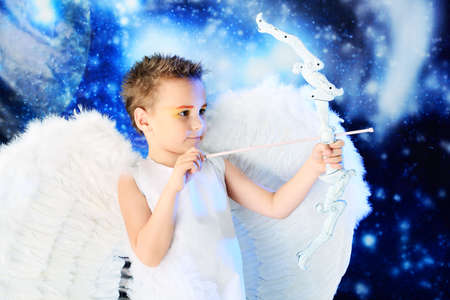 Beautiful little angel at a snowy background.の写真素材