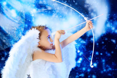 Beautiful little angel at a snowy background.の写真素材