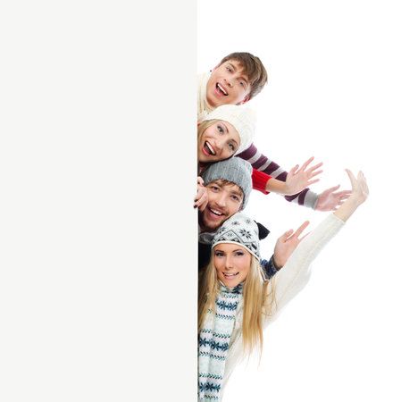 Group of young people in warm clothes looking out  white board.