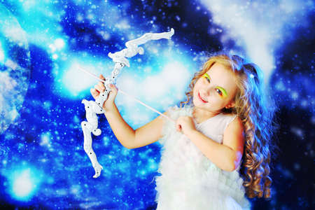 Beautiful little angel at a snowy background.の写真素材