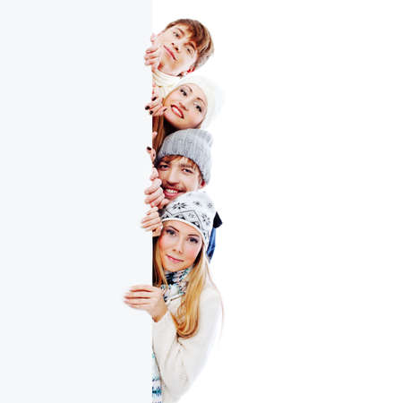 Group of young people in warm clothes looking out  white board.の写真素材