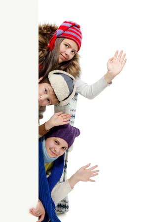 Group of teenagers in warm clothes looking out white board.の写真素材