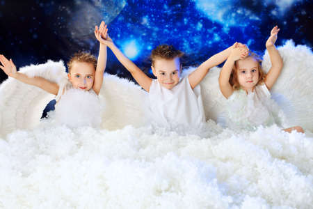 Beautiful little angels at a snowy background.の写真素材