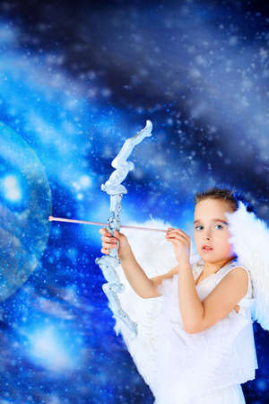 Beautiful little angel at a snowy background.