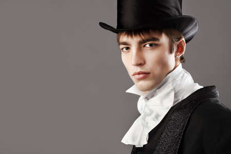 Portrait of a young gentlemen wearing dinner jacket and black top hat. Shot in a studio.の写真素材