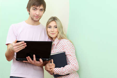 Happy young couple with a laptop at home.の写真素材