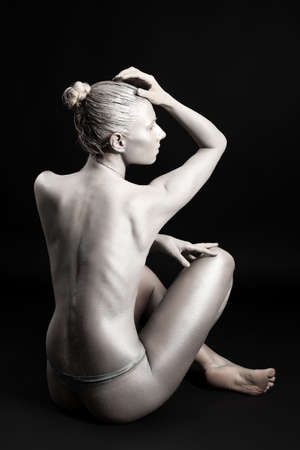 Portrait of an artistic woman painted in metal style. Shot in a studio.の写真素材