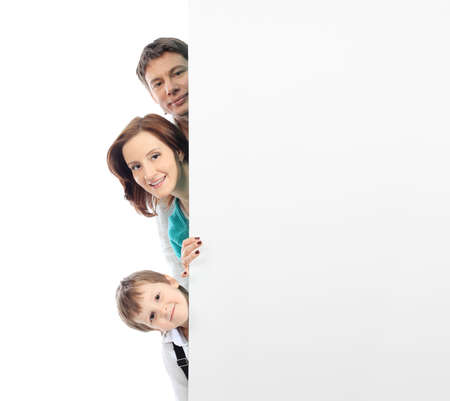 Portrait of a happy family looking out of a billboard. Isolated over white background.の写真素材