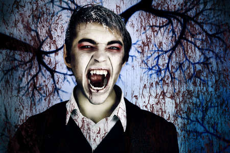 Portrait of a handsome young man with vampire style make-up. Shot in a studio.の写真素材