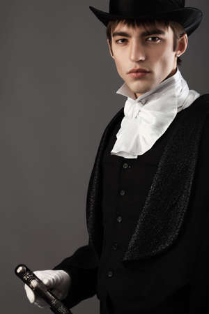 Portrait of a young gentlemen wearing dinner jacket and black top hat. Shot in a studio.の写真素材