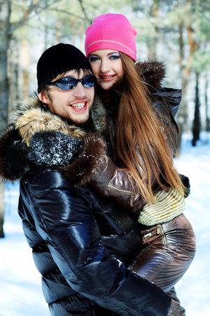 Portrait of a young couple having a rest in winter park.の写真素材