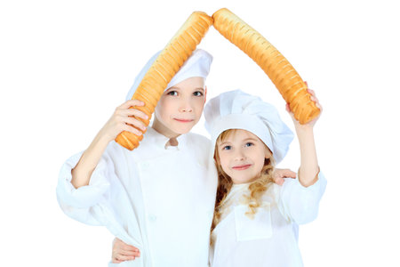 Shot of a little kitchen boy and girl in a white uniform. Isolated over white background.の写真素材