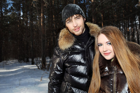 Portrait of a young couple having a rest in winter park.の写真素材