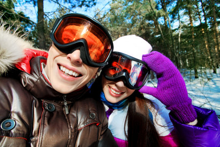 Portrait of a happy young couple having a rest in winter park.の写真素材