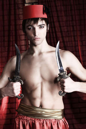 Shot of a man in oriental costume holding daggers.の写真素材