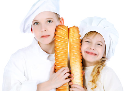 Shot of a little kitchen boy and girl in a white uniform. Isolated over white background.