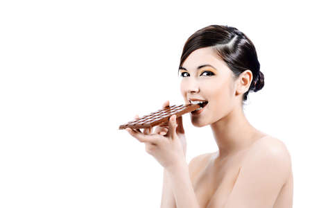 Shot of a beautiful young woman holding big chocolate bar.の写真素材