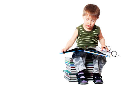 Portrait of a cute little boy with books. Isolated over white background.の写真素材
