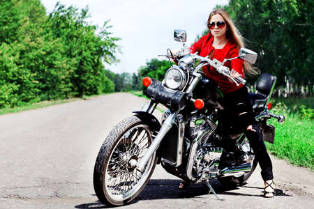 Shot of an attractive woman biker posing on her motorcycle.の写真素材