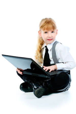 Shot of a little girl sitting on a floor with her laptop. Isolated over white background.の写真素材