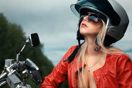 Shot of an attractive woman biker posing near her motorcycle.の写真素材