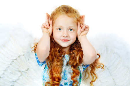 Portrait of a cute red-haired girl angel. Isolated over white background.の写真素材