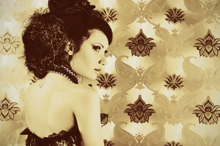 Beautiful fashionable woman over vintage background.の写真素材