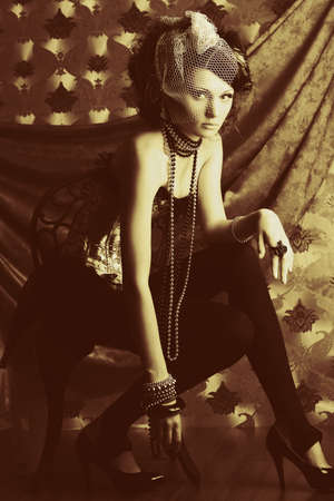 Beautiful fashionable woman over vintage background.の写真素材