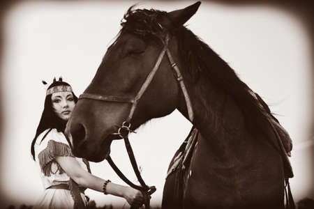 Beautiful young woman posing with a brown horse.の写真素材