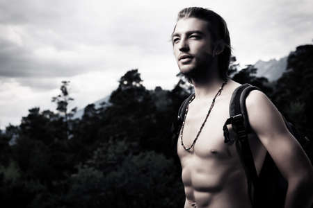 Handsome young man tourist standing at mountains.の写真素材