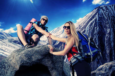 Couple of tourists are standing at the top of a mountain with a feeling of freedom.の写真素材
