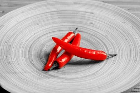 Shot of red peppers on a round wooden plate.の写真素材
