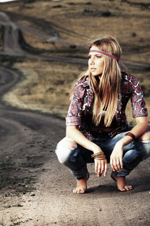 Beautiful young woman hippie posing over picturesque landscape.