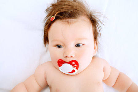 Portrait of a beautiful baby lying on a white towel.の写真素材