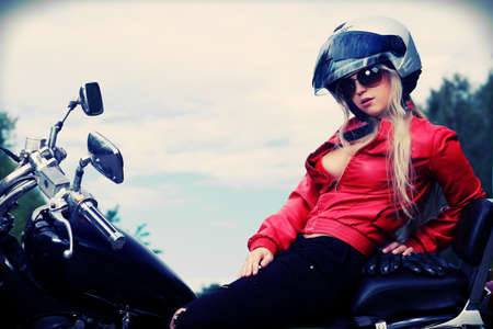 Shot of an attractive woman biker posing near her motorcycle.の写真素材