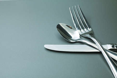 Silver fork, knife and spoon  over grey background.の写真素材
