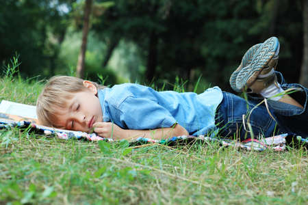 Shot of a little boy having a rest outdoor.の写真素材
