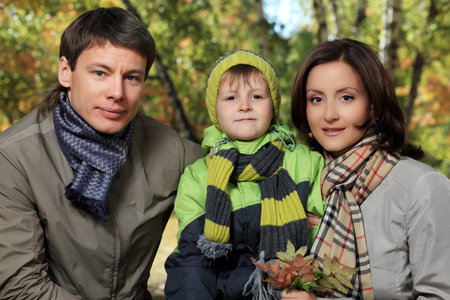 Happy family walking at the autumn park.