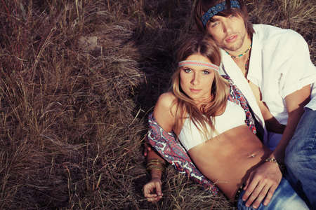 Beautiful young couple hippie posing together over picturesque landscape.の写真素材