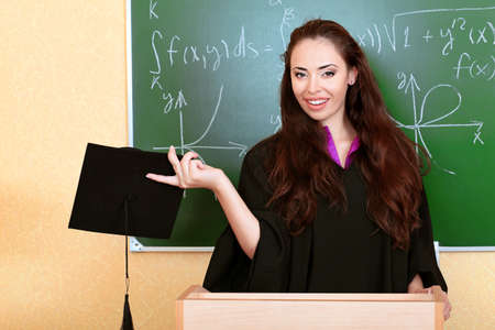 Educational theme: graduating student in academic gown in a classroom.の写真素材