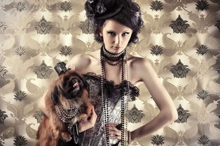 Portrait of a fashionable lady with a dog over vintage background.の写真素材