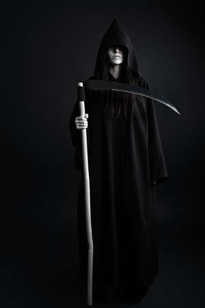 Woman death reaper over black background. Halloween.の写真素材