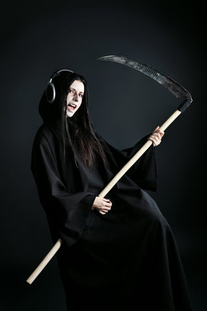 Woman death reaper over black background. Halloween.の写真素材