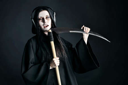 Woman death reaper over black background. Halloween.の写真素材