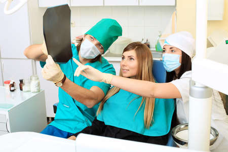 Shot of a young woman with dentists in a dental surgery. Healthcare, medicine.の写真素材