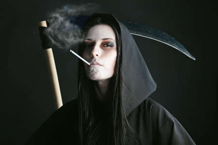 Woman death reaper over black background. Halloween.の写真素材