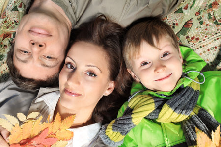 Happy family having a rest at the autumn park.の写真素材