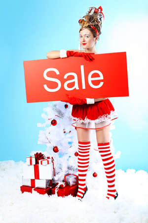 Beautiful young woman in Santa Claus clothes over Christmas background.の写真素材